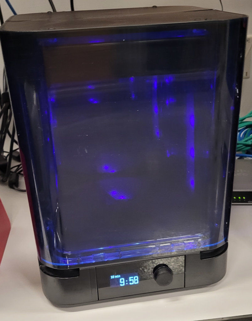 A UV curing station with a timer set to 9:58.